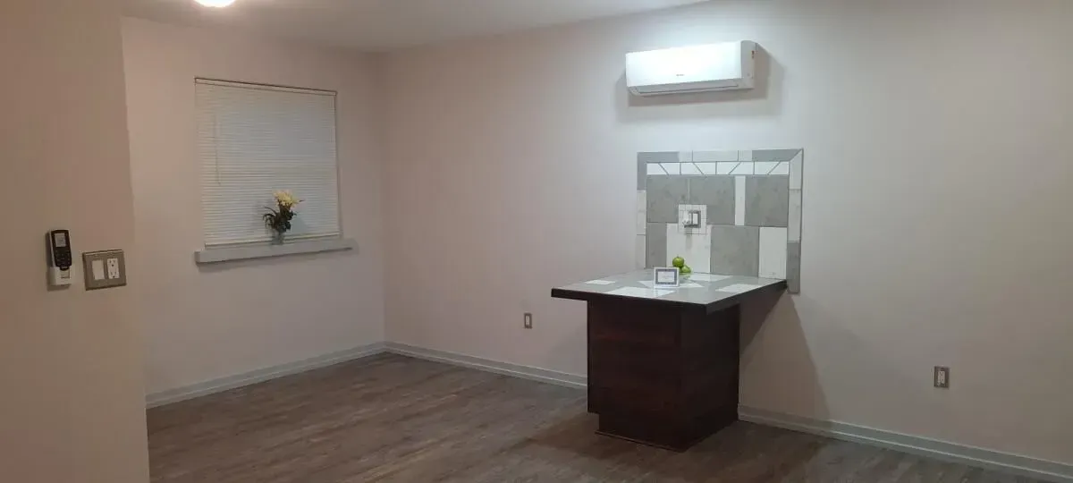 An empty room with a table and a window.