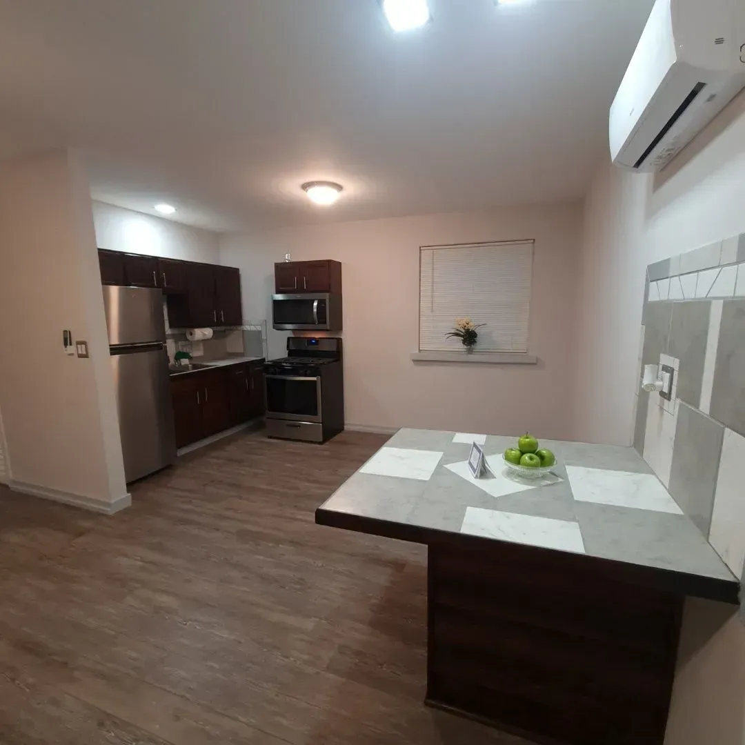 A kitchen with a table and a bowl of apples on it