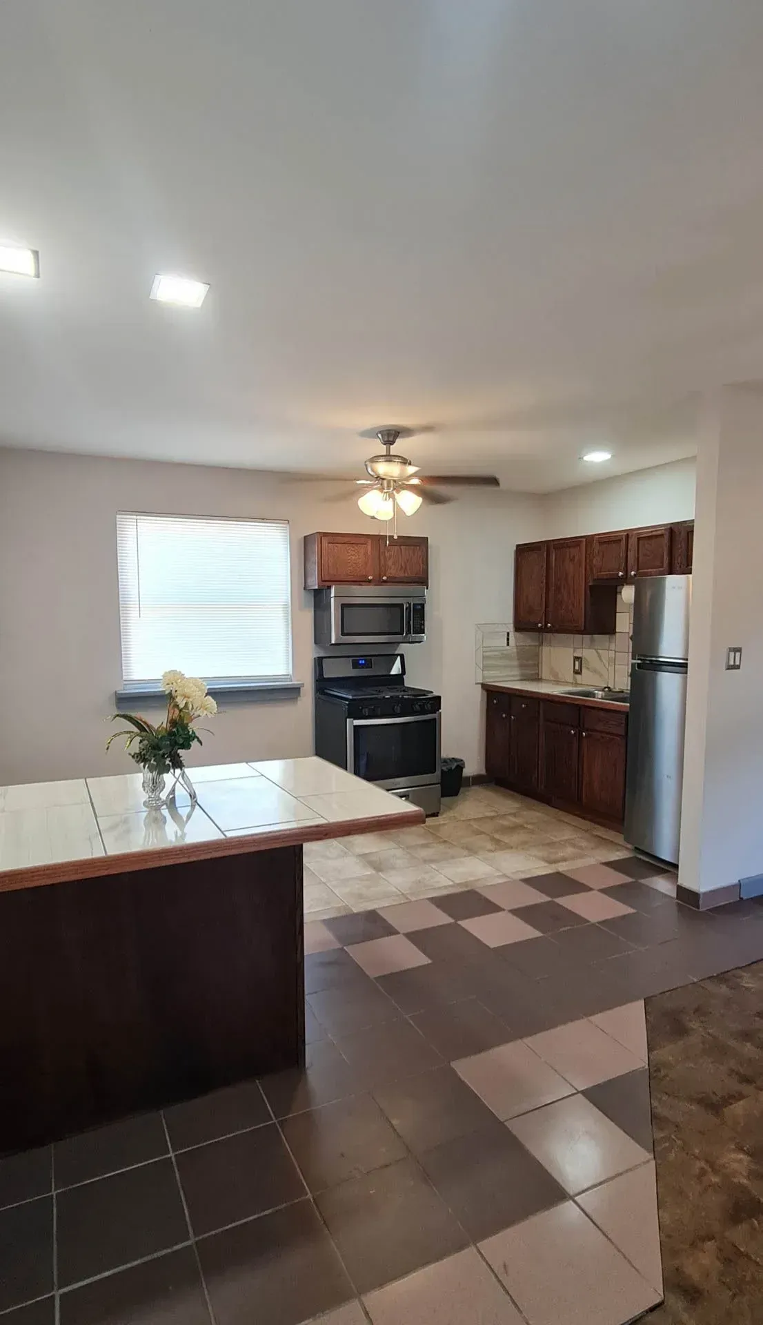 A kitchen with a refrigerator , stove , microwave , and sink.