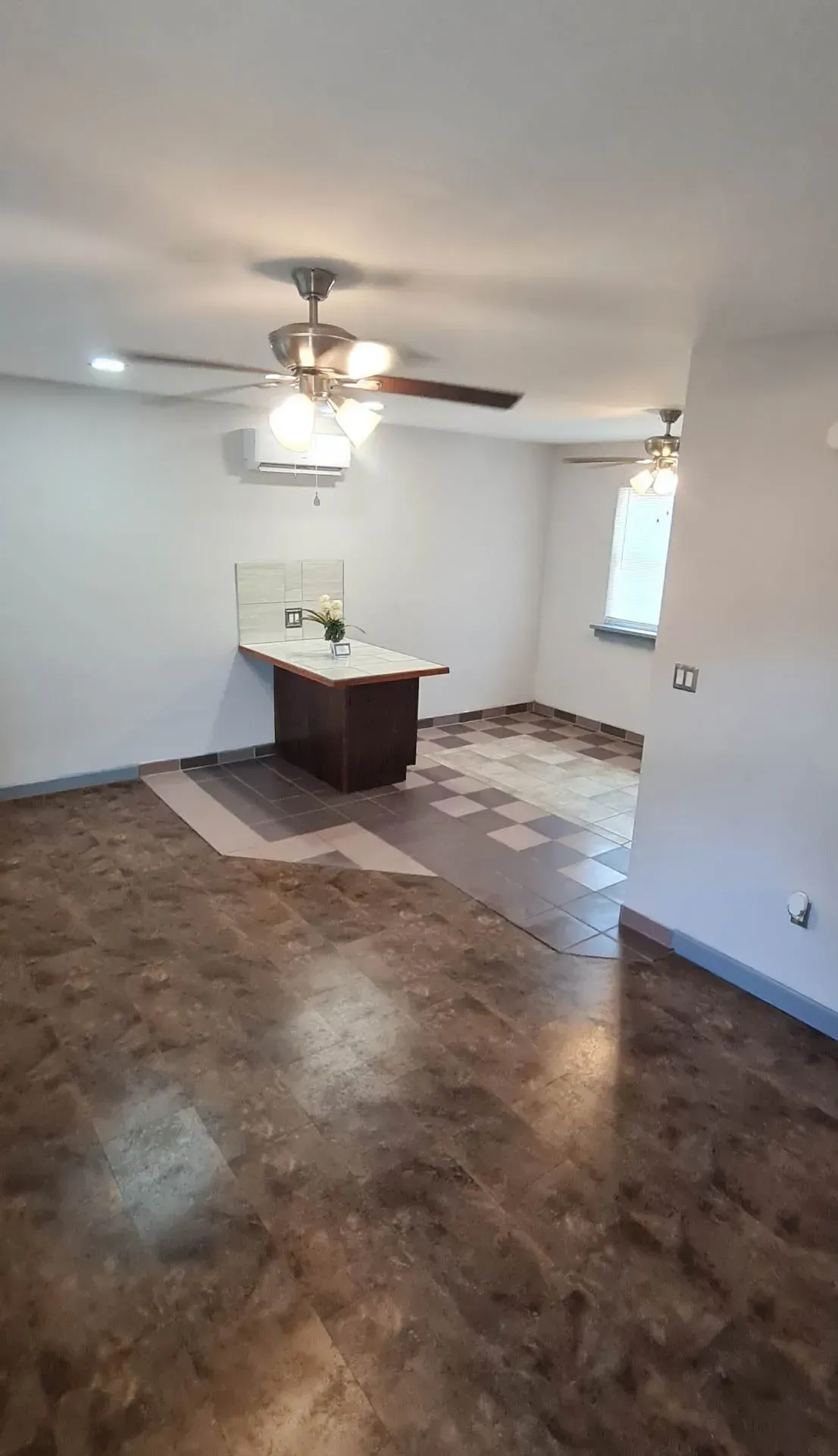 A living room with a ceiling fan and a table.