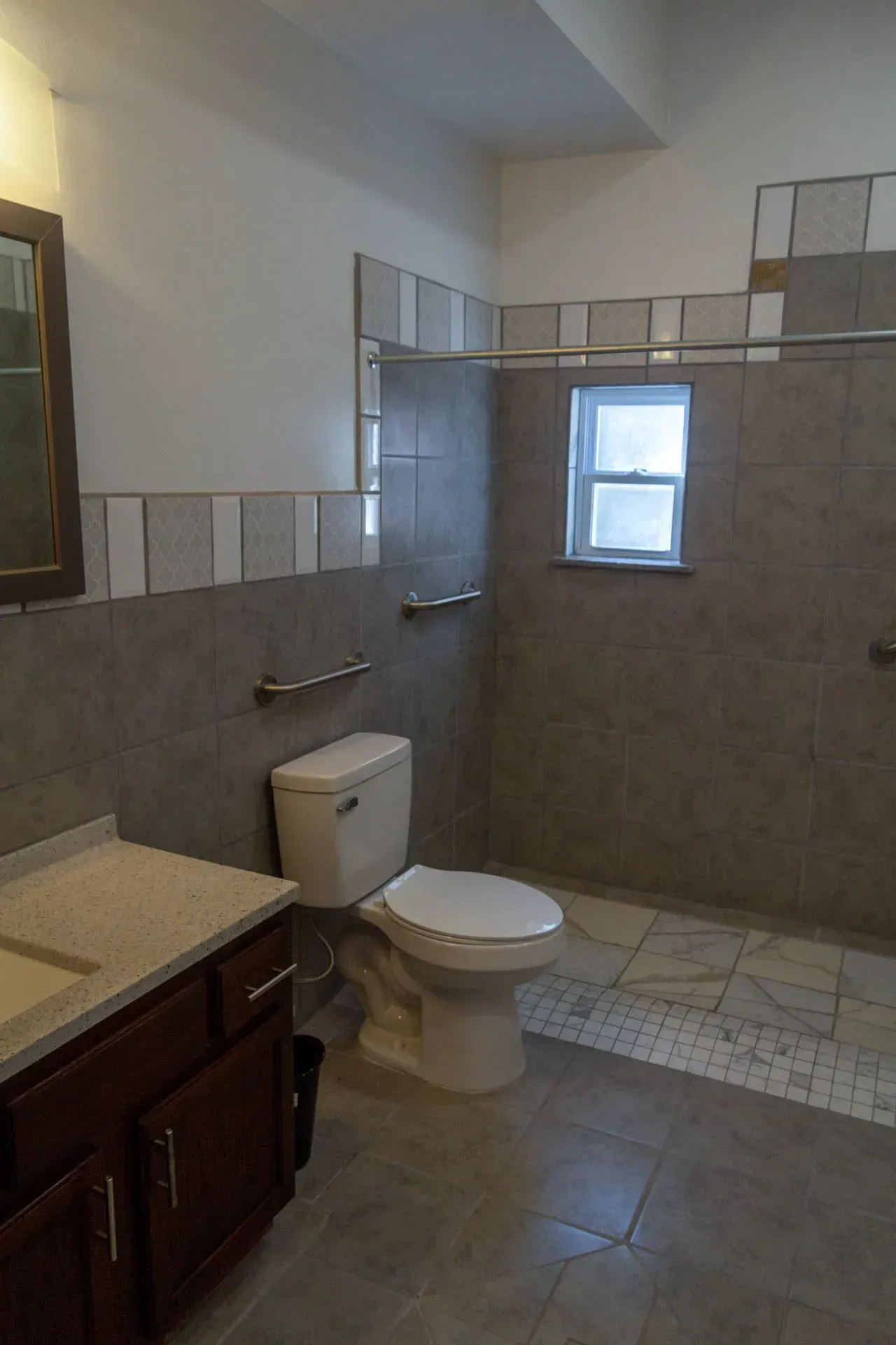 A bathroom with a toilet , sink and shower.