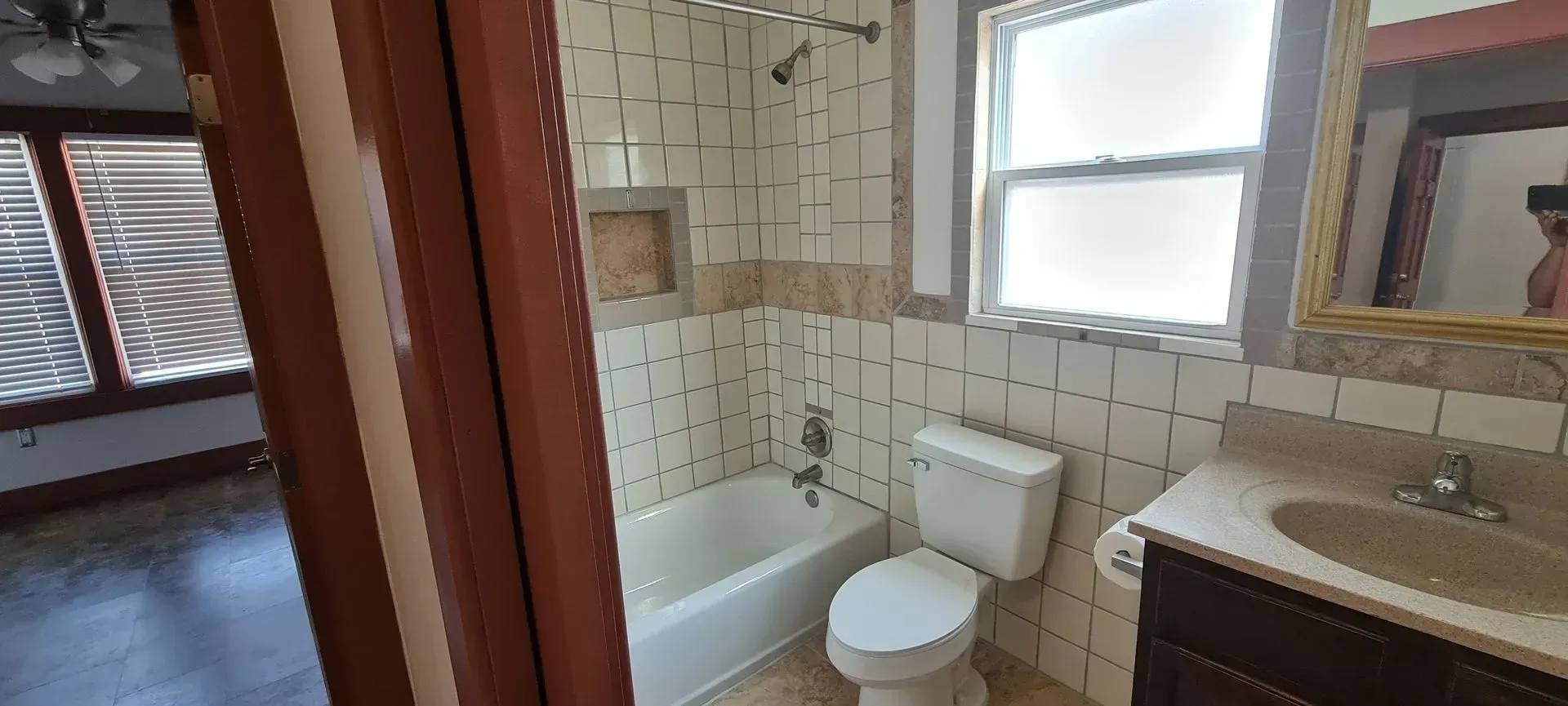 A bathroom with a toilet , sink and bathtub.