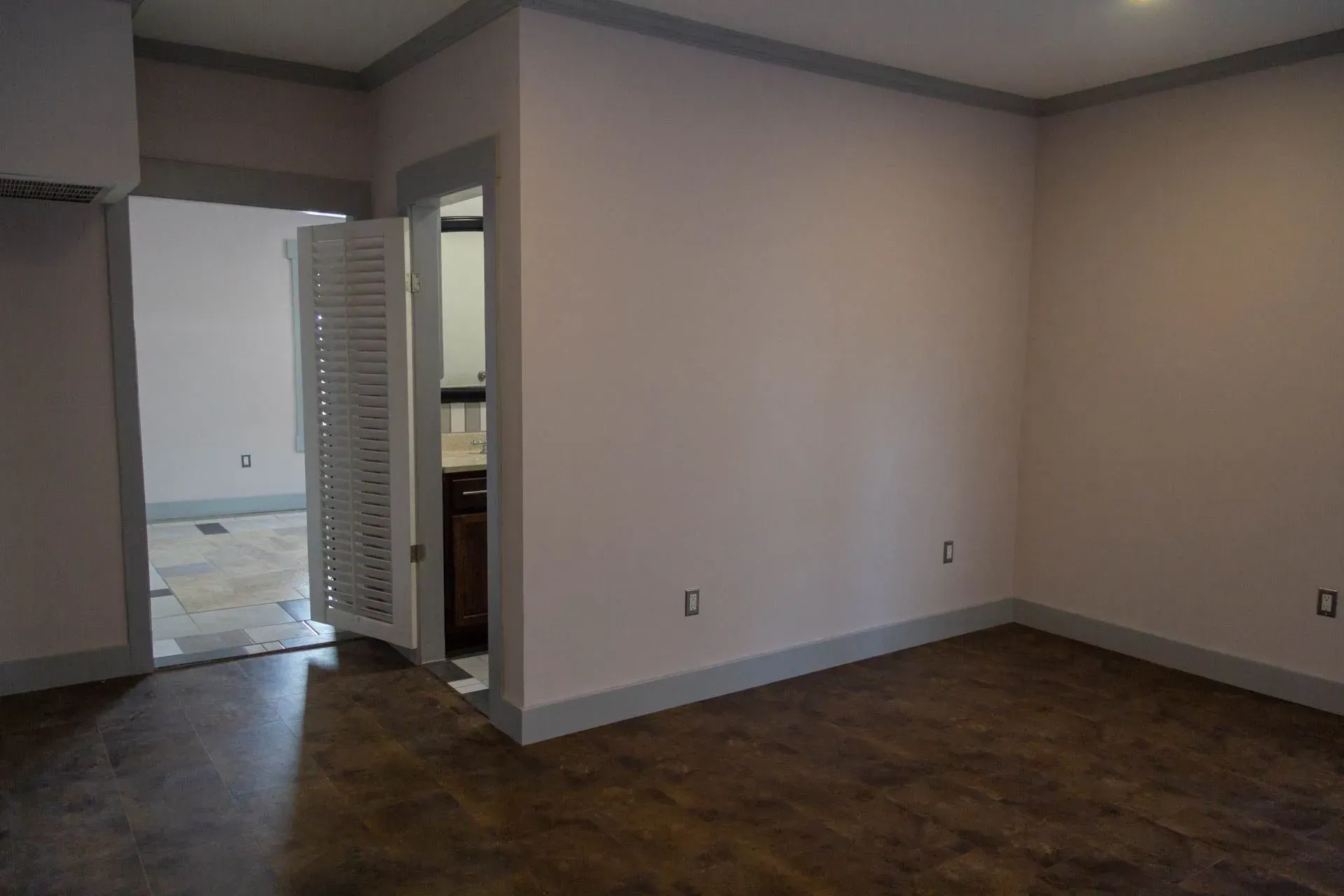 An empty room with a wooden floor and white walls