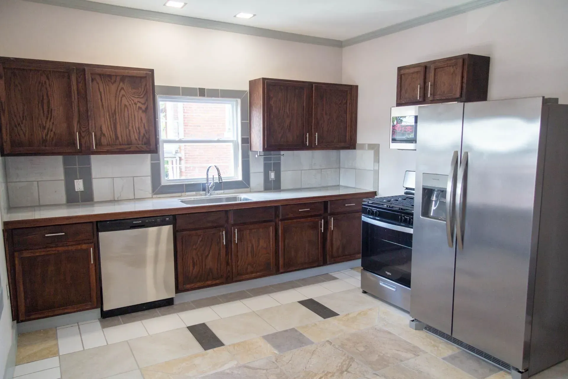 A kitchen with stainless steel appliances and wooden cabinets