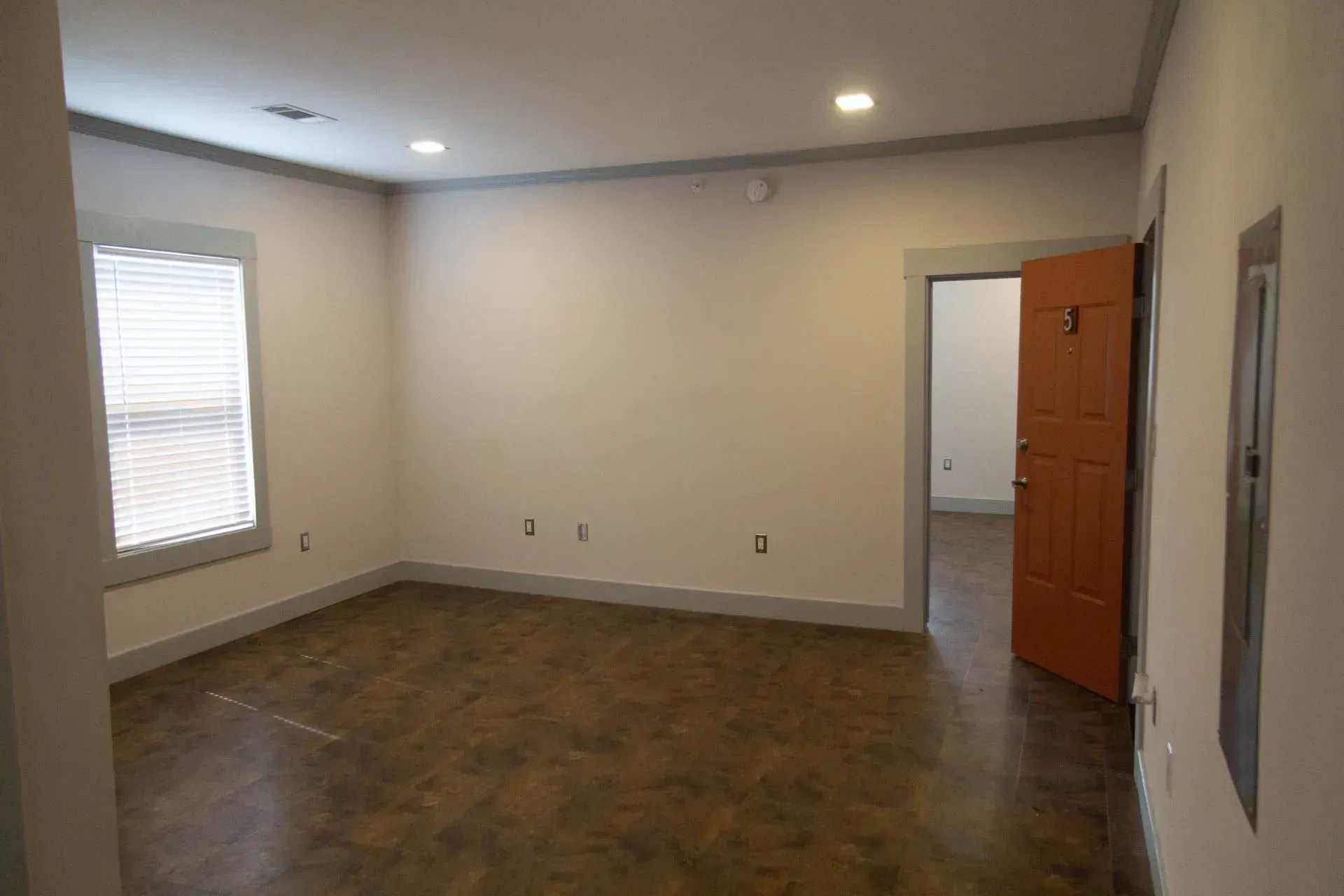 An empty room with a window and a door.