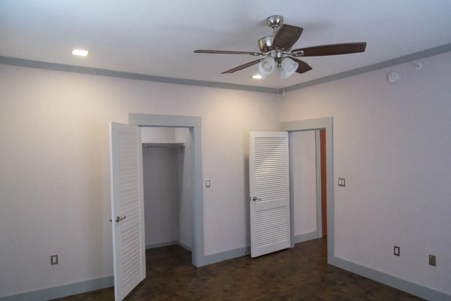 There is a ceiling fan in the corner of the room.