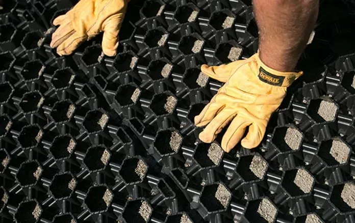 A Person Wearing Yellow Gloves is Standing on a Black Mat — Blue River Landscape Supplies in Foulden, QLD