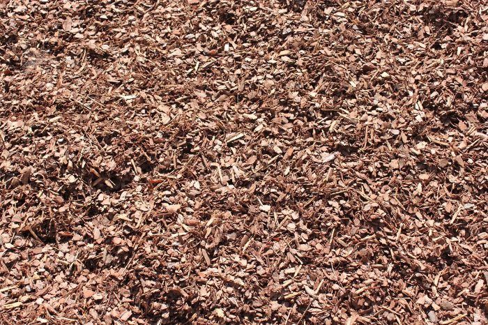 A Pile of Brown Wood Chips is Sitting on the Ground — Blue River Landscape Supplies in Foulden, QLD