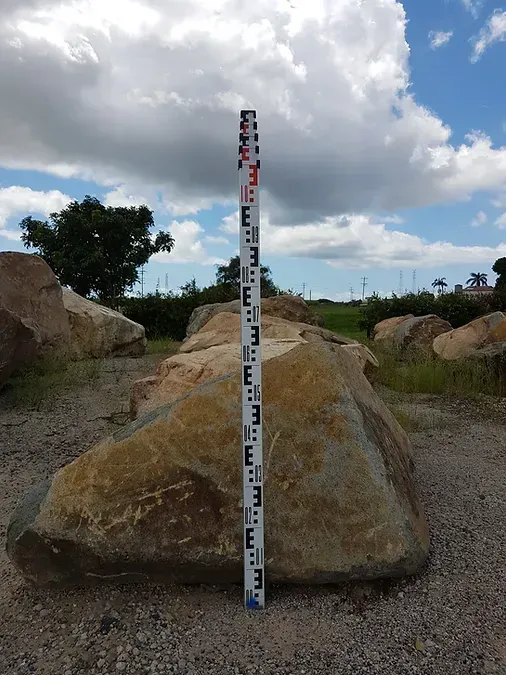 A Measuring Stick is Standing Next to a Large Rock — Blue River Landscape Supplies in Foulden, QLD