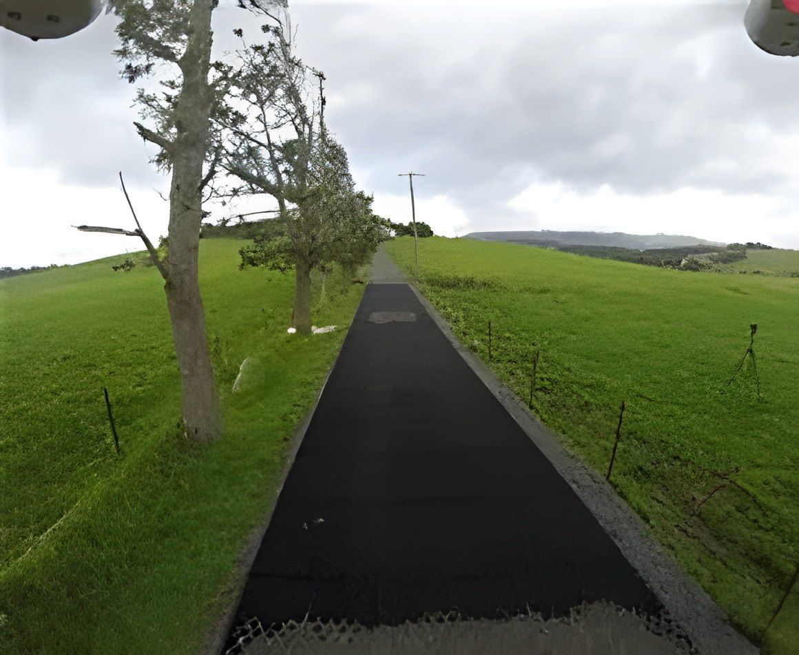 A Road Going Through a Grassy Field With Trees on Both Sides — Blue River Landscape Supplies in Foulden, QLD