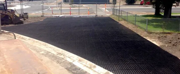 A Black Asphalt Road is Being Built Next to a Fence — Blue River Landscape Supplies in Foulden, QLD