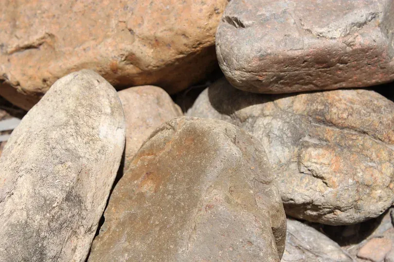 A Pile of River Rocks Oversize Sitting on Top of Each Other on the Ground — Blue River Landscape Supplies in Foulden, QLD
