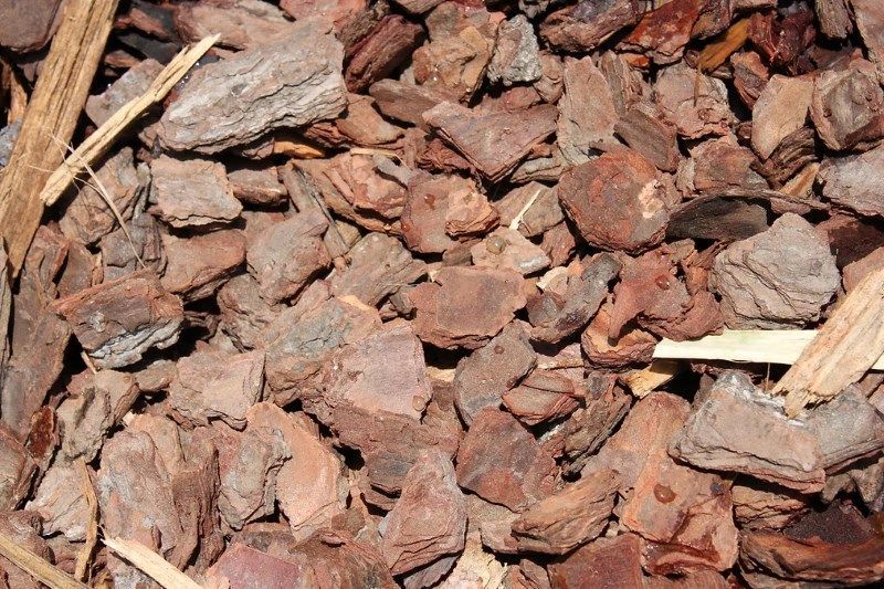 A Pile of Brown Rocks and Pine Bark on the Ground — Blue River Landscape Supplies in Foulden, QLD