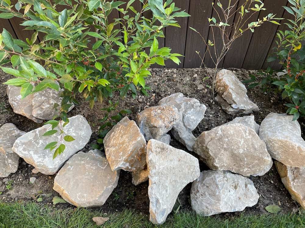 A Pile Of Rocks Sitting On Top Of A Lush Green Field — Blue River Landscape Supplies in Foulden, QLD