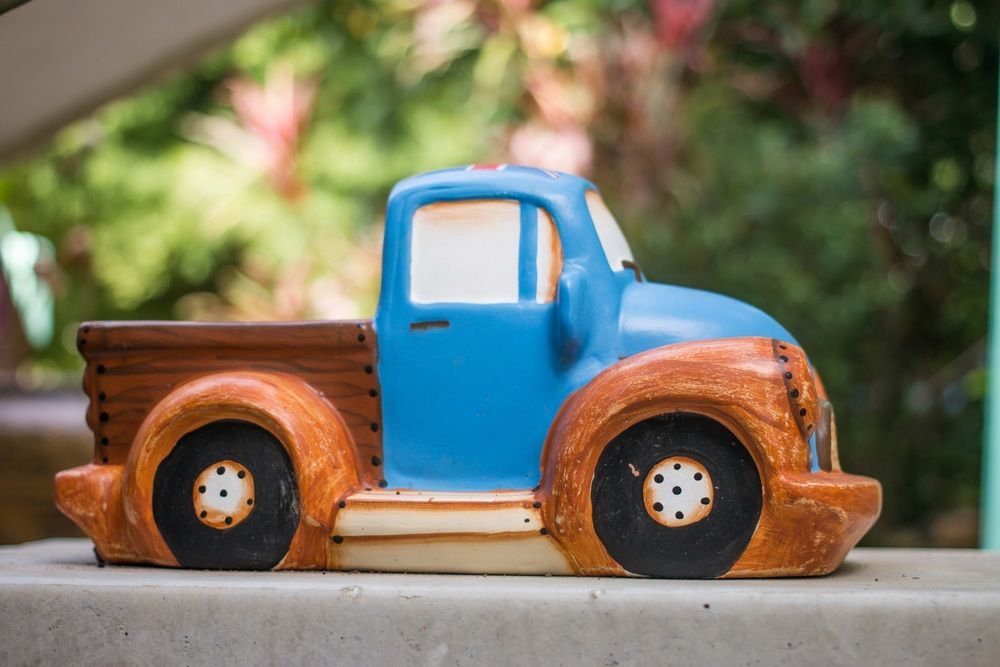 A Blue and Brown Toy Truck is Sitting on a Concrete Surface — Blue River Landscape Supplies in Foulden, QLD