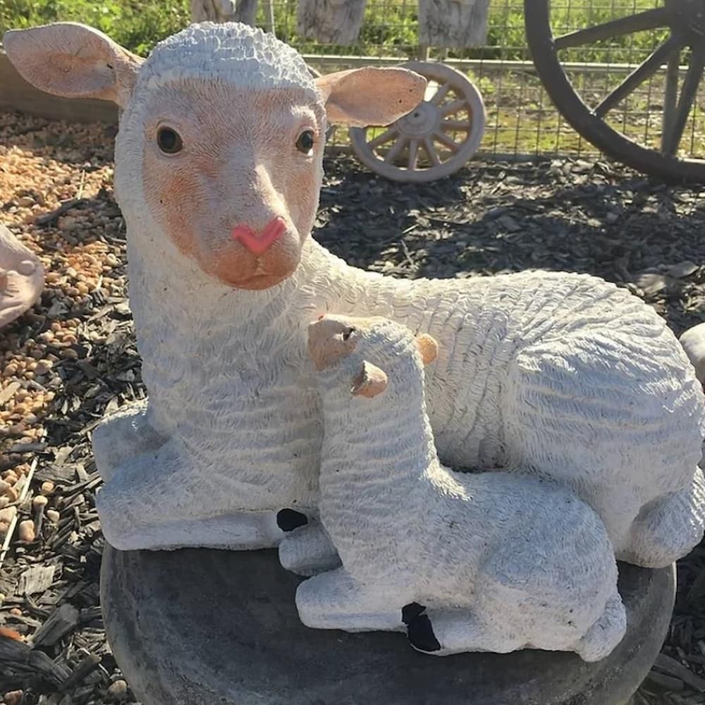 A Statue of Two Sheep Laying on a Rock — Blue River Landscape Supplies in Foulden, QLD