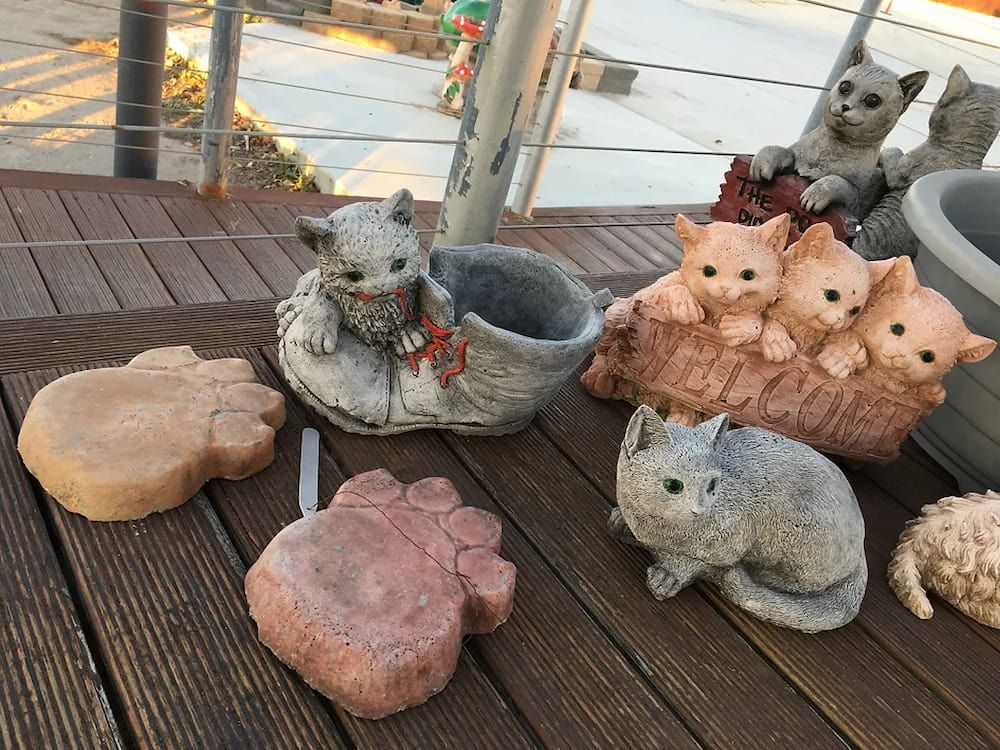 A Group of Statues of Cats Are Sitting on a Wooden Table — Blue River Landscape Supplies in Foulden, QLD