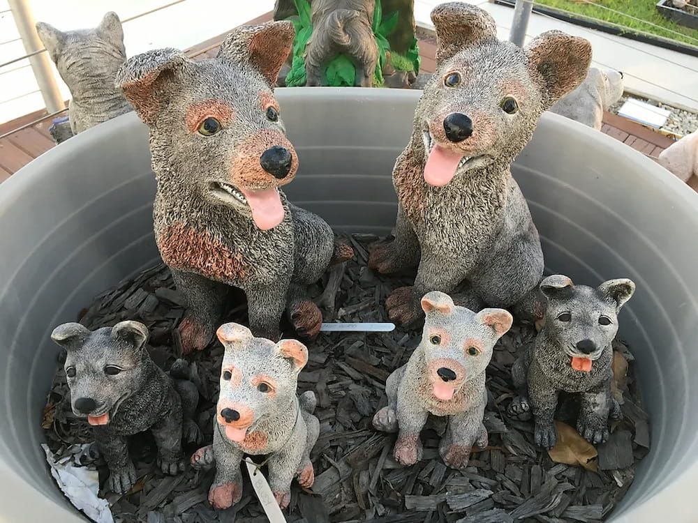 A Group of Statues of Dogs Are Sitting in a Pot — Blue River Landscape Supplies in Foulden, QLD