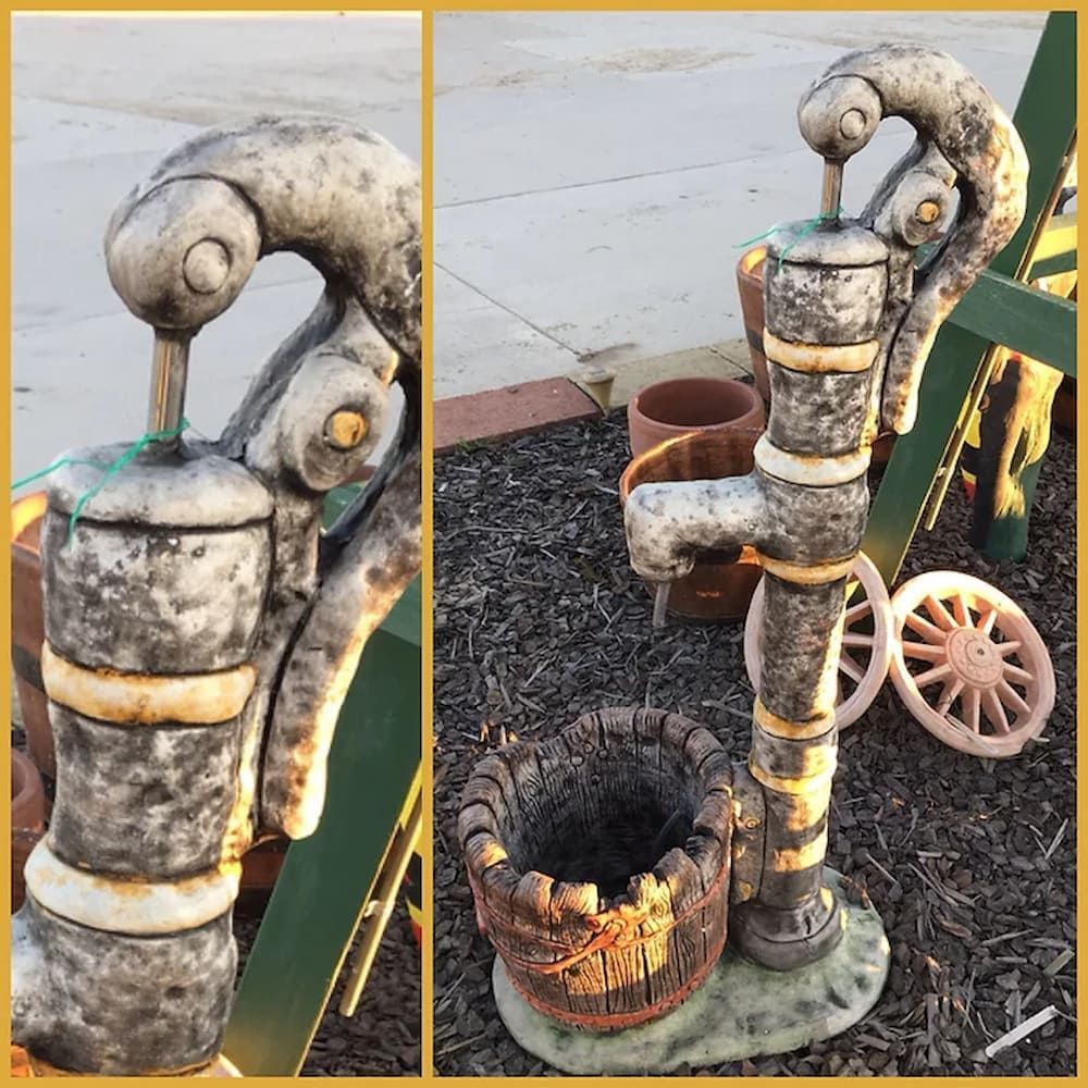 A Statue of a Water Pump With a Bucket Attached to It — Blue River Landscape Supplies in Foulden, QLD