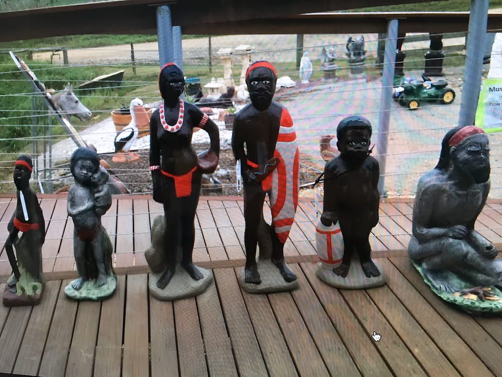 A Group of Statues Are Lined Up on a Wooden Deck — Blue River Landscape Supplies in Foulden, QLD