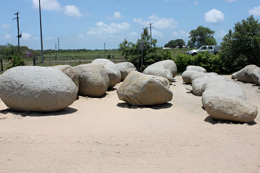A Bunch of Large Rocks Are Sitting in the Sand  — Blue River Landscape Supplies in Foulden, QLD