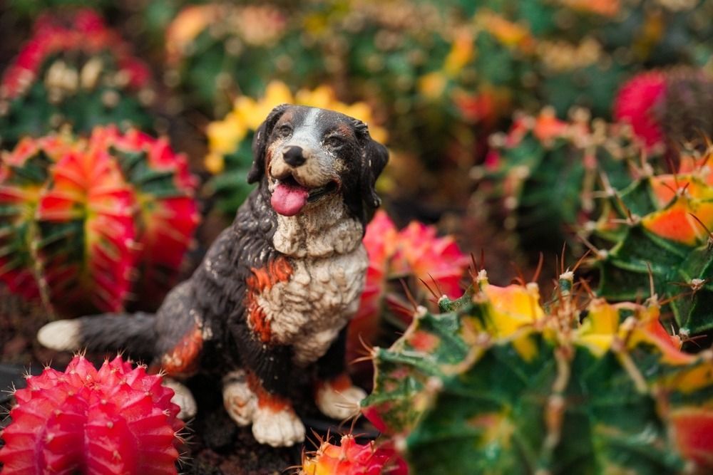 A Statue of a Dog is Sitting in a Field of Flowers — Blue River Landscape Supplies in Foulden, QLD