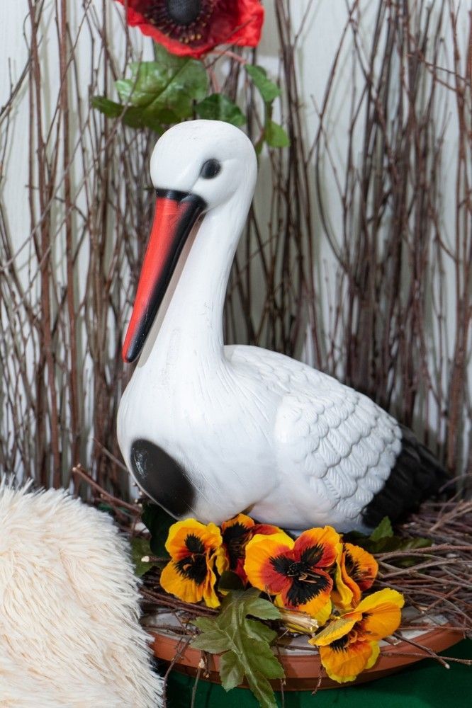 A Statue of a Stork Sitting in a Nest With Flowers — Blue River Landscape Supplies in Foulden, QLD