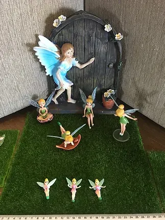 A Group of Fairy Figurines Sitting on Top of a Lush Green Field — Blue River Landscape Supplies in Foulden, QLD