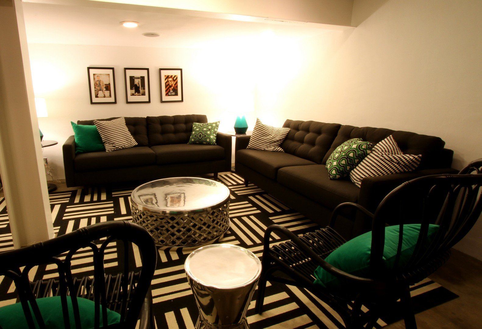 Living room with dark gray sofas, black and white rug, and black chairs.