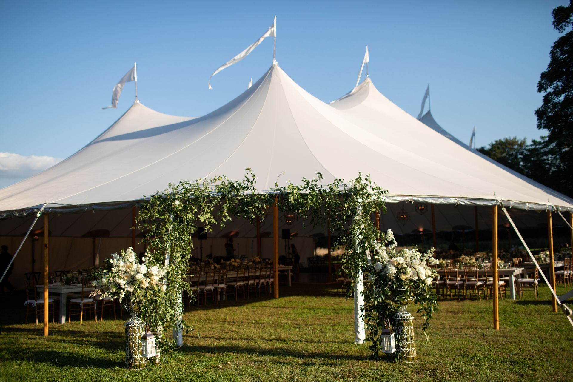 Dining tables under a tent with floral decor.