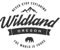 A black and white logo for wildland oregon with a bear and mountains.