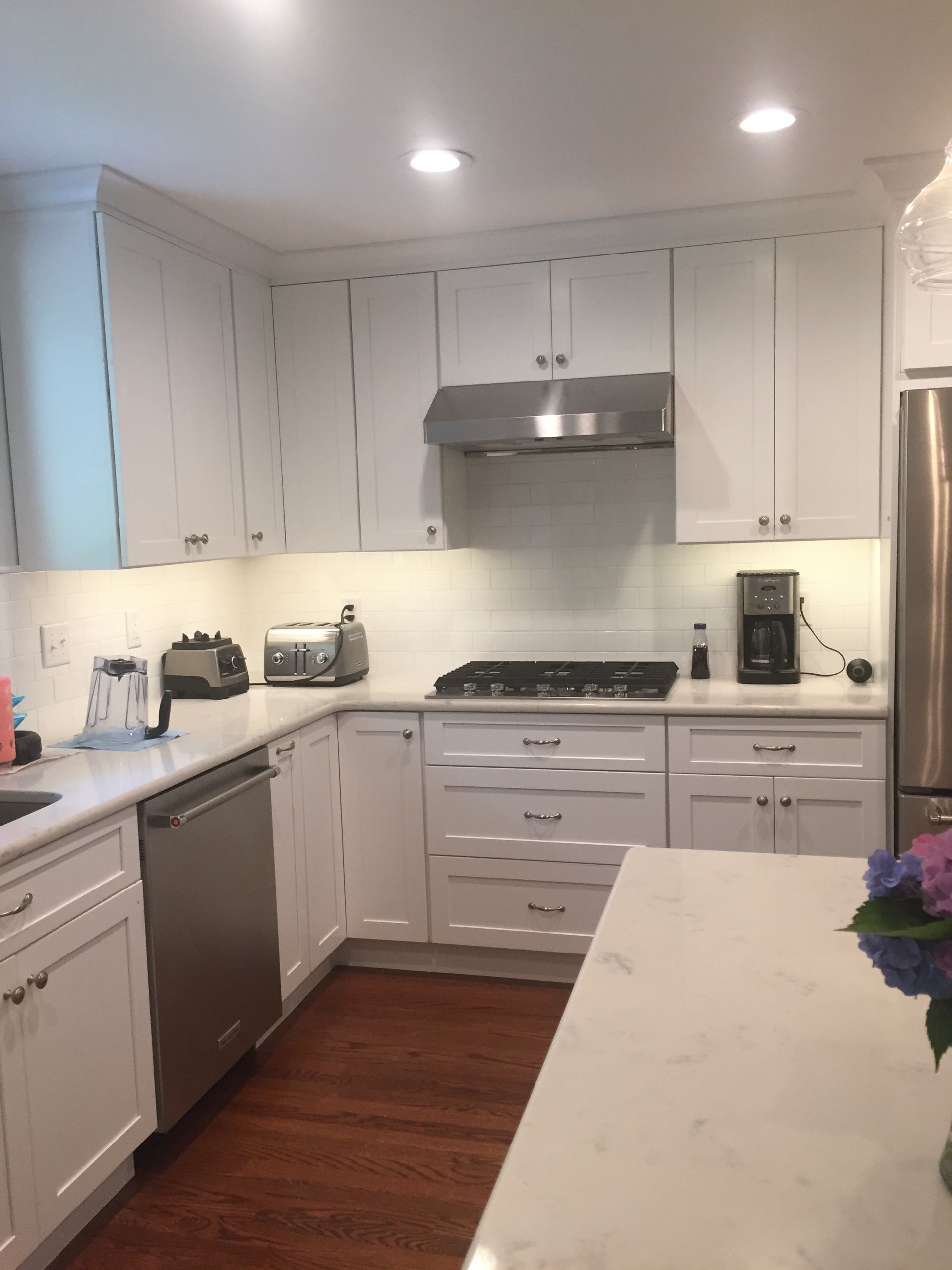 A kitchen with white cabinets and stainless steel appliances