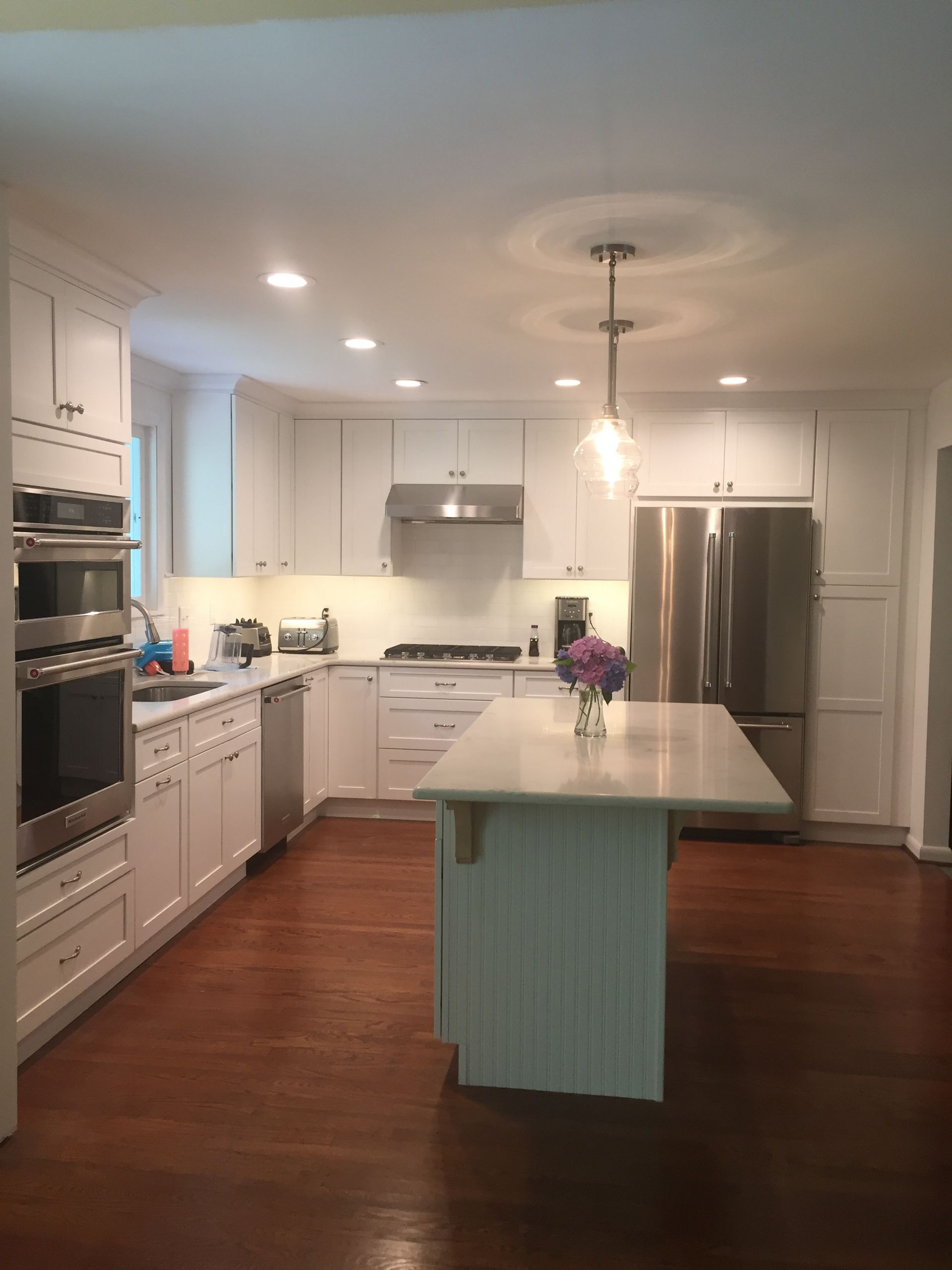 A kitchen with white cabinets and stainless steel appliances