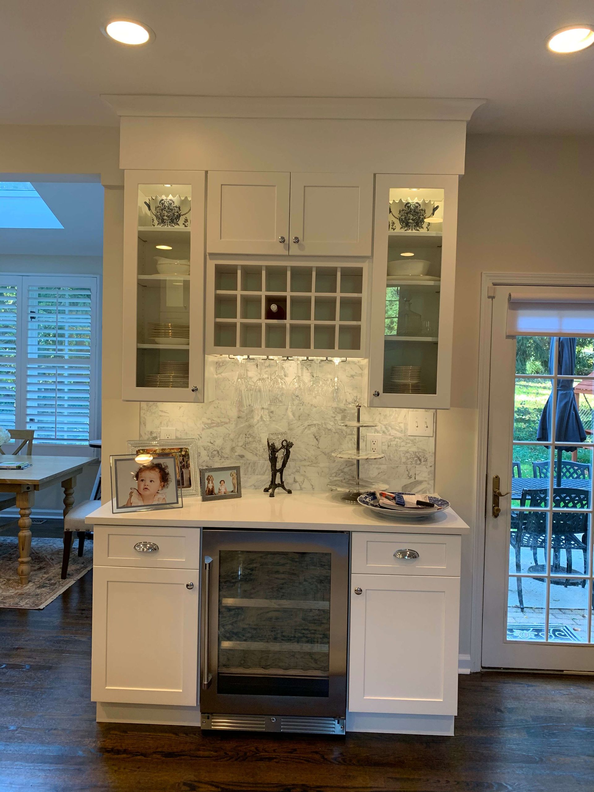 A kitchen with white cabinets and a wine cooler.