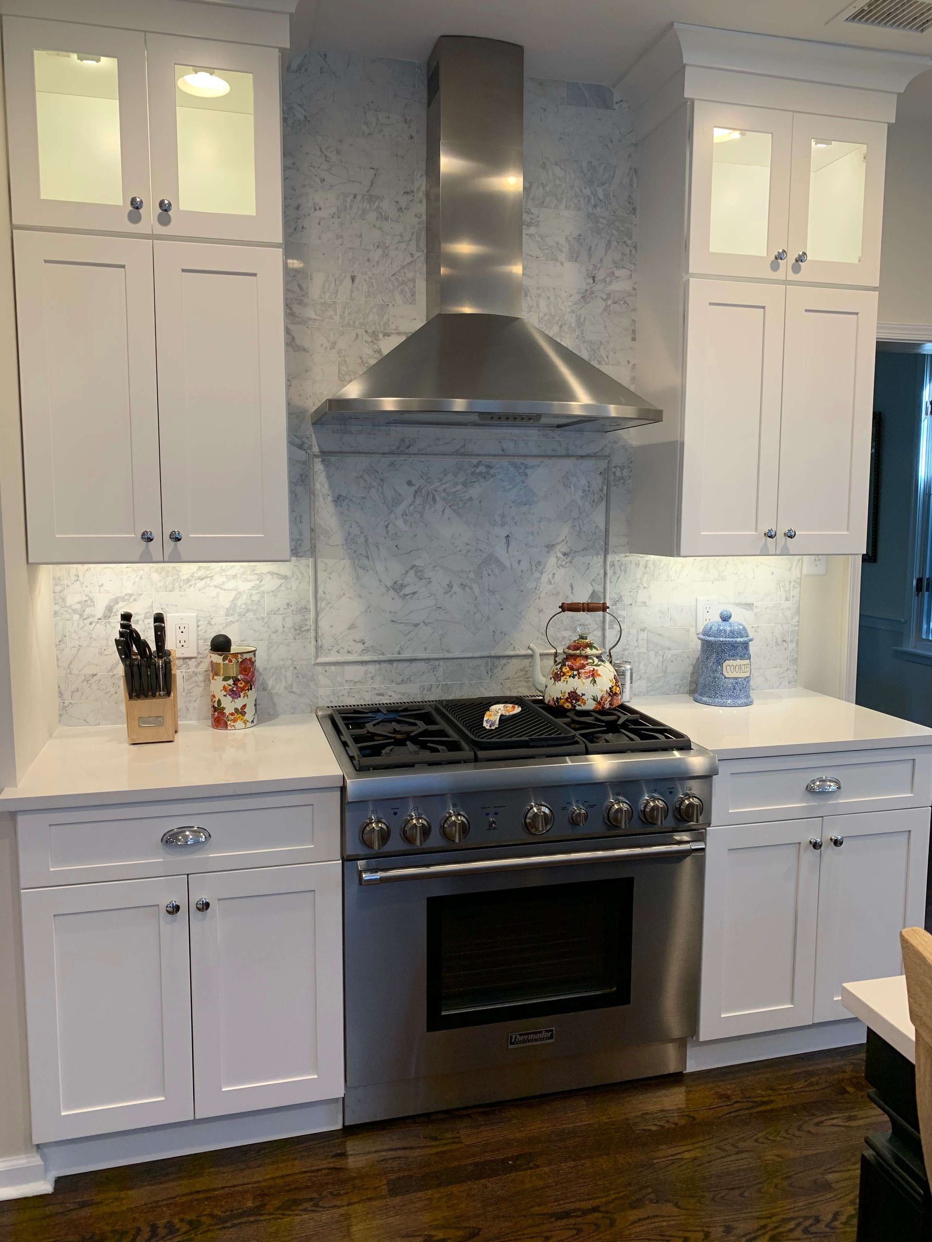 A kitchen with stainless steel appliances and white cabinets