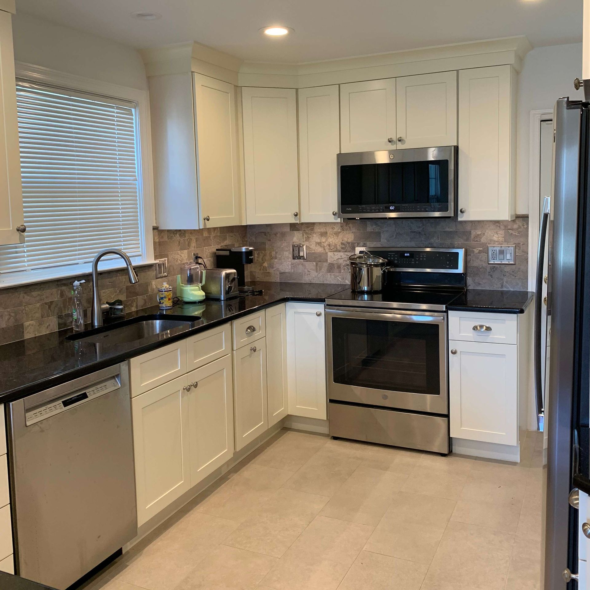 A kitchen with stainless steel appliances and white cabinets