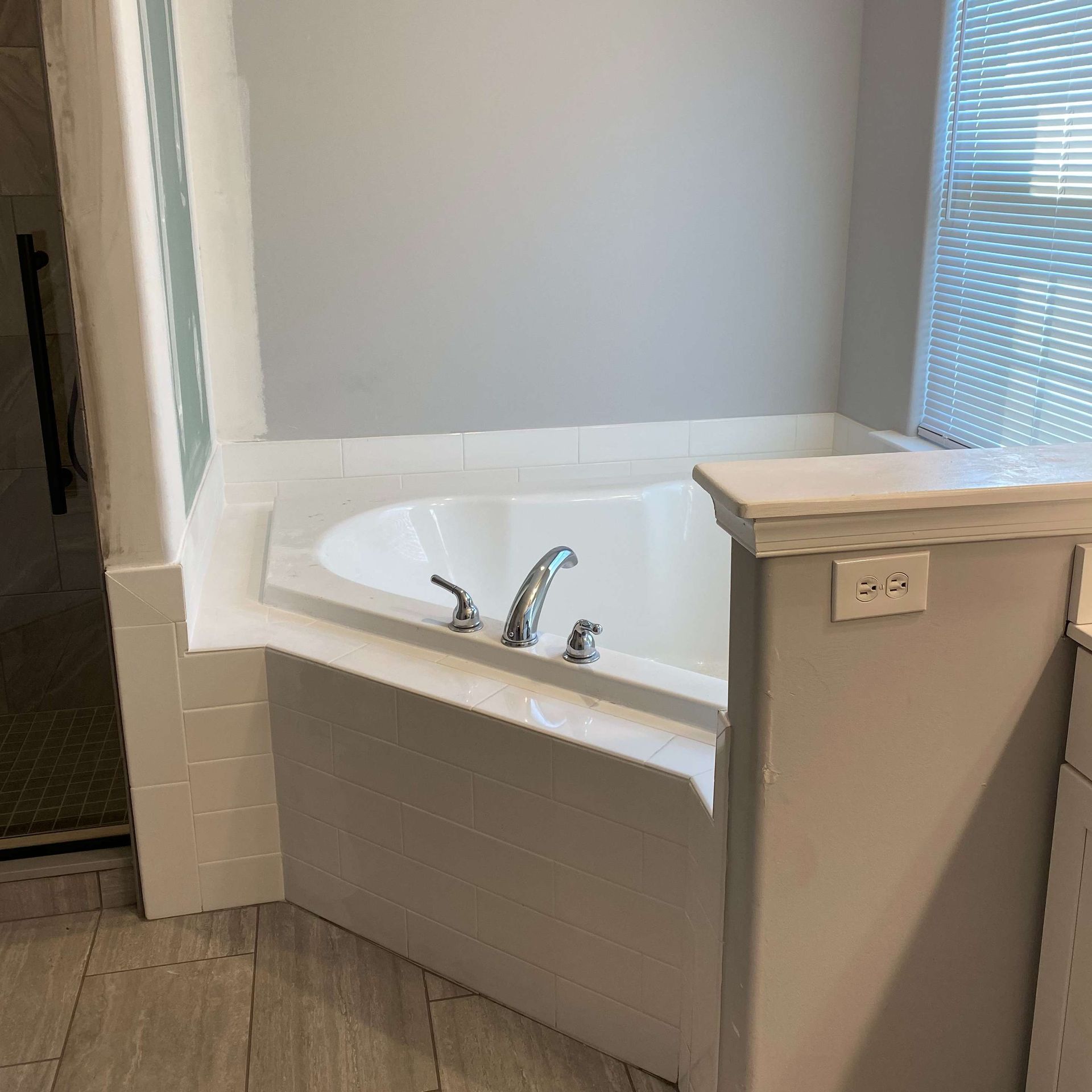 A jacuzzi tub in a bathroom next to a window.