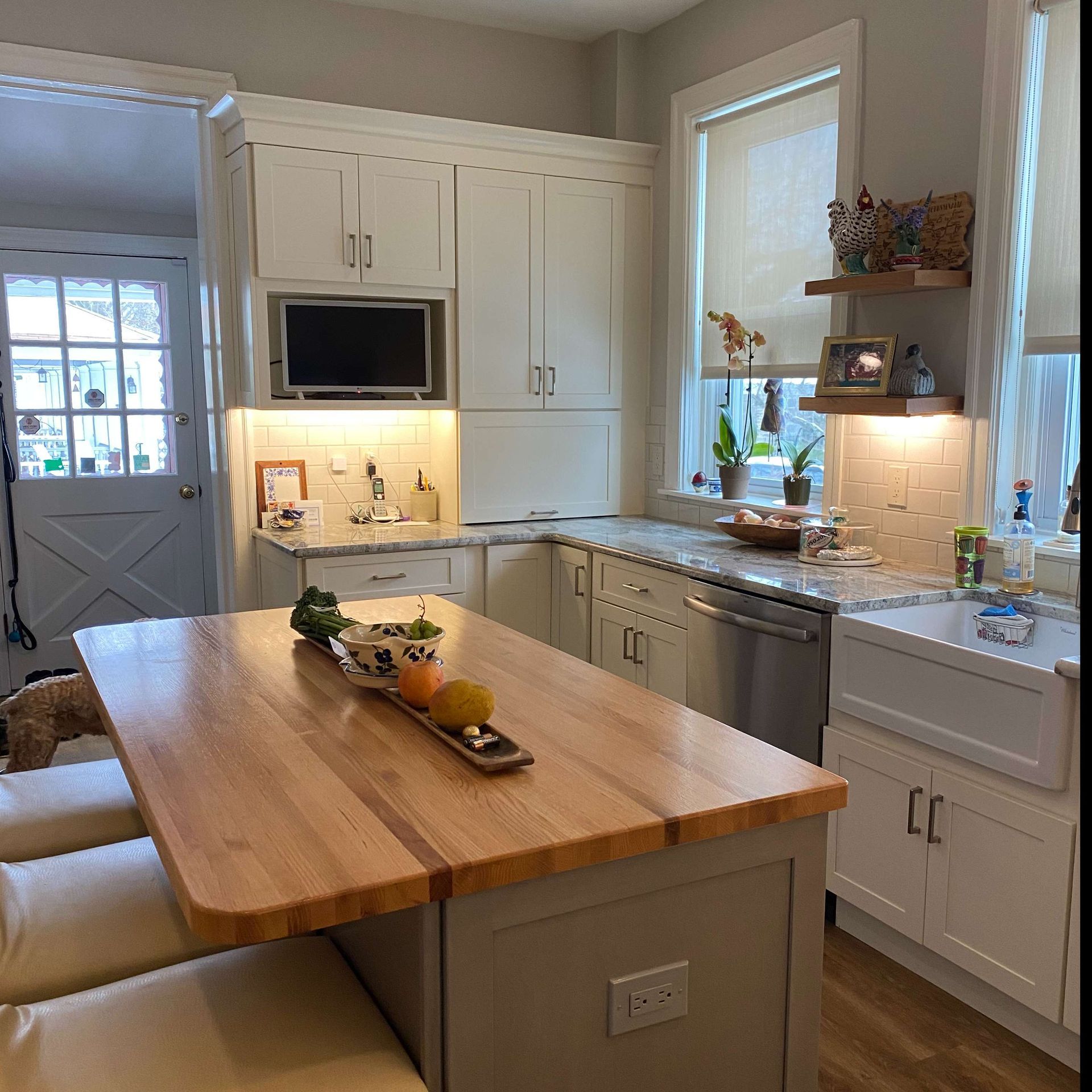 A kitchen with white cabinets and a wooden table