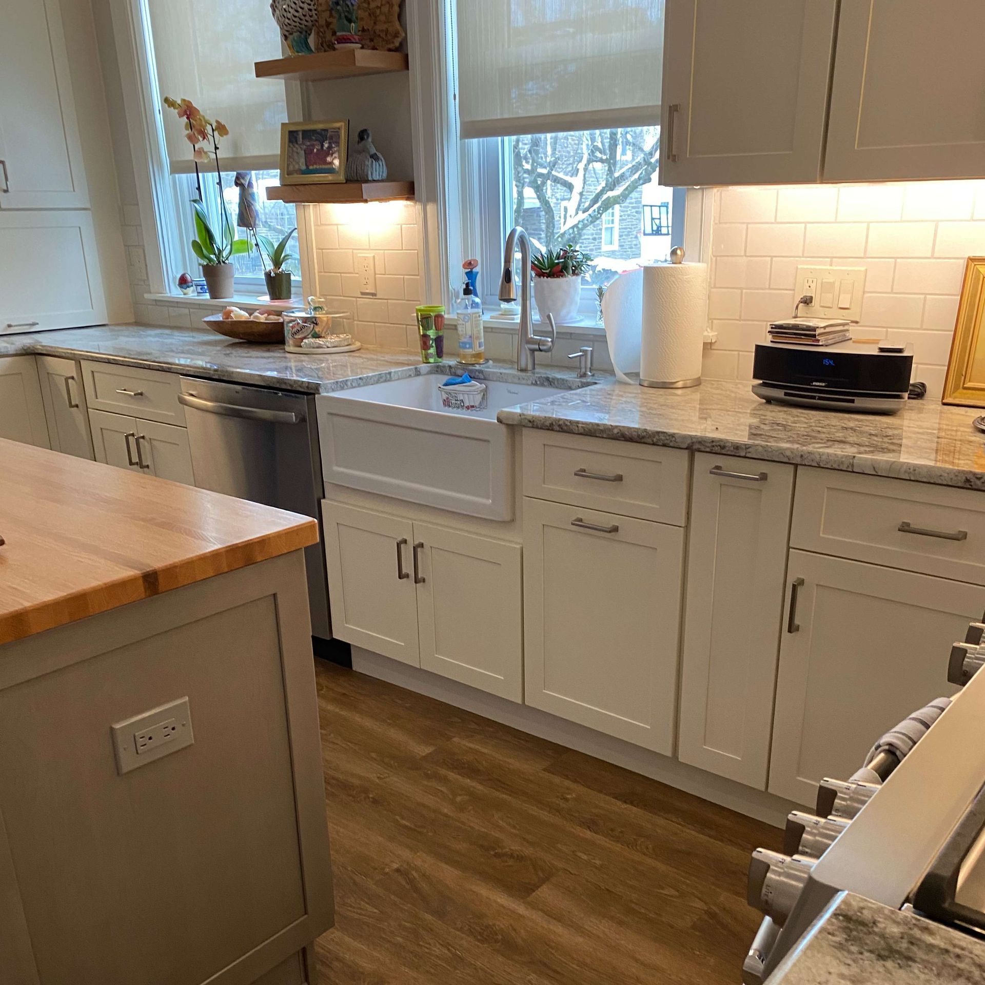 A kitchen with white cabinets and a wooden counter top
