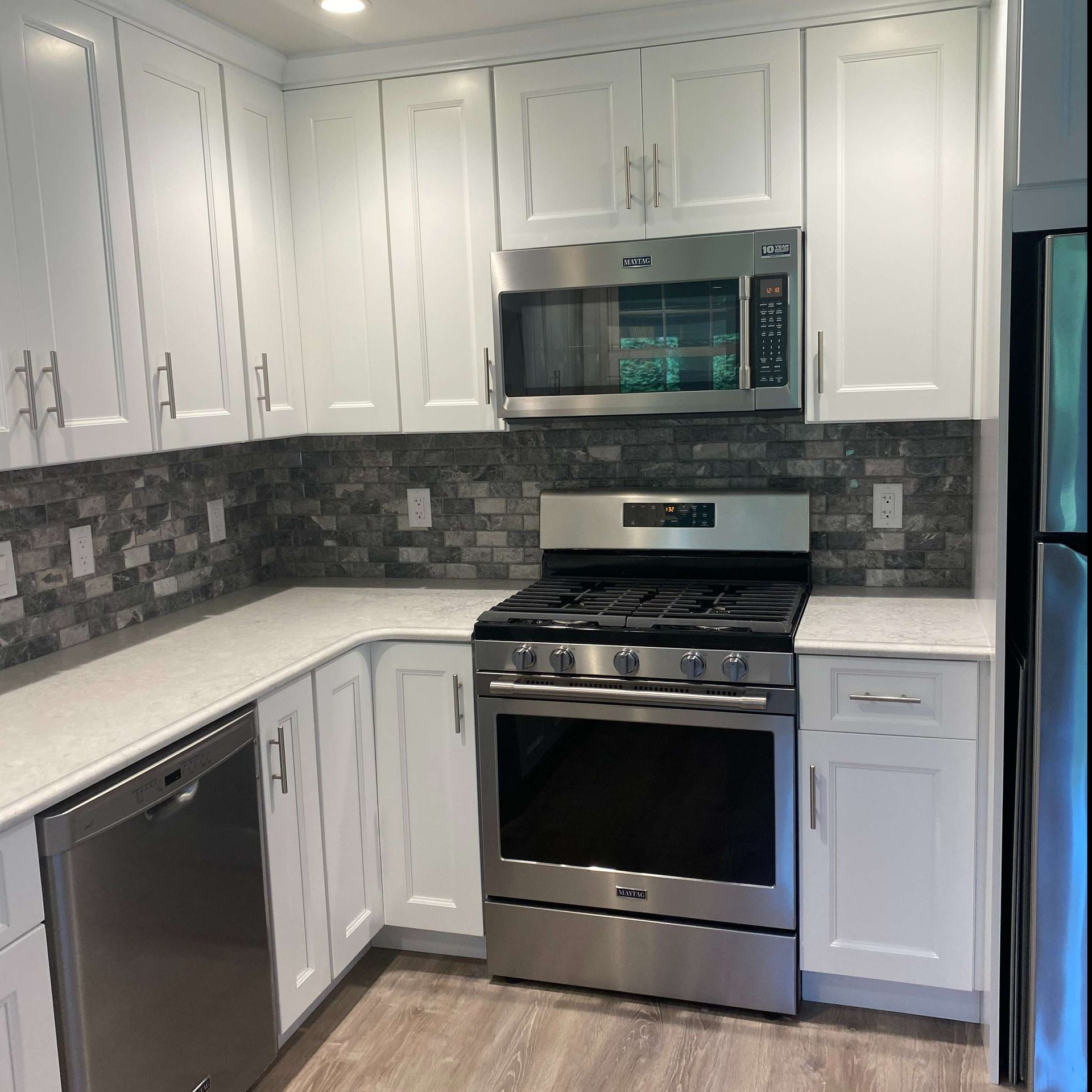A kitchen with stainless steel appliances and white cabinets