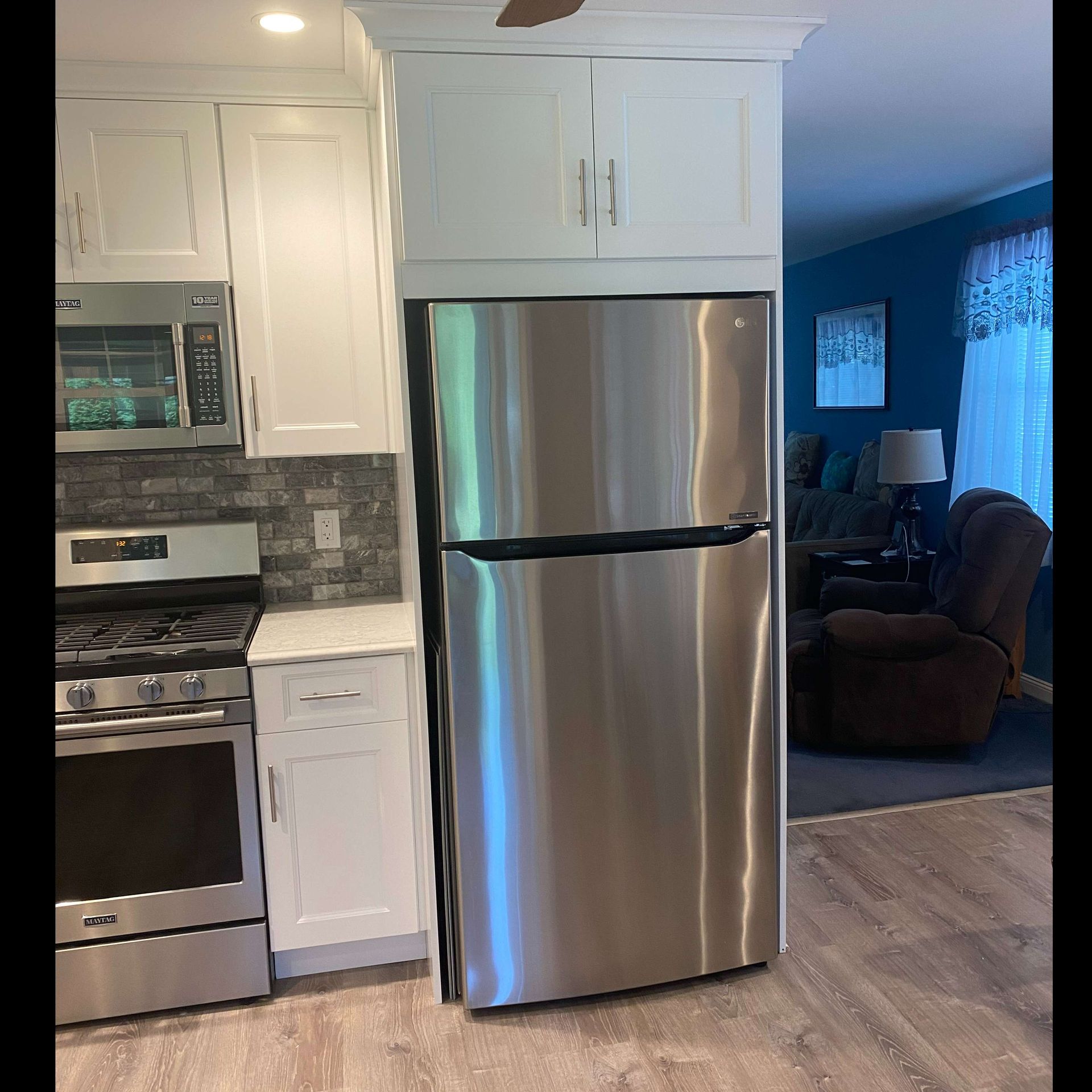 A stainless steel refrigerator is sitting in a kitchen next to a stove.