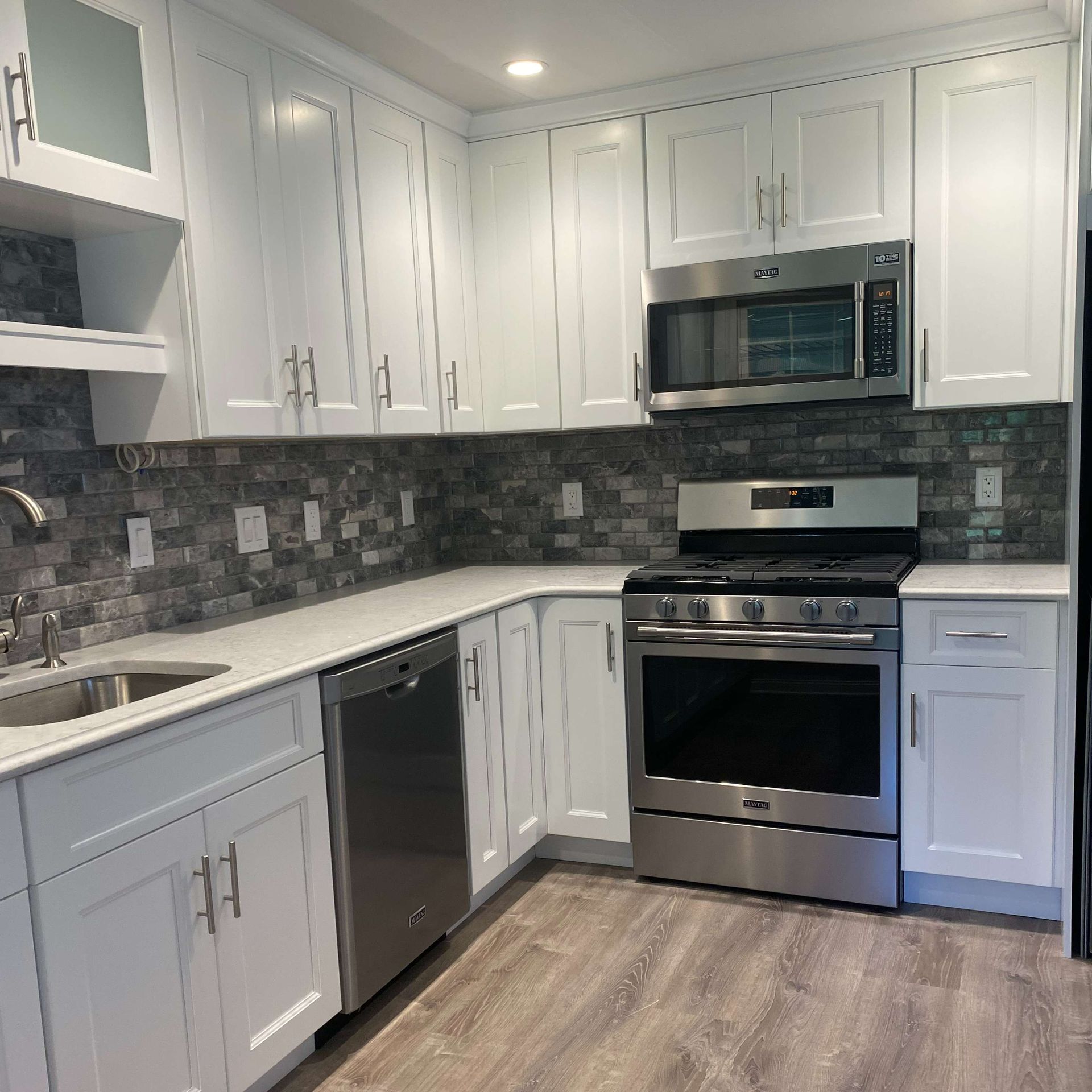 A kitchen with stainless steel appliances and white cabinets