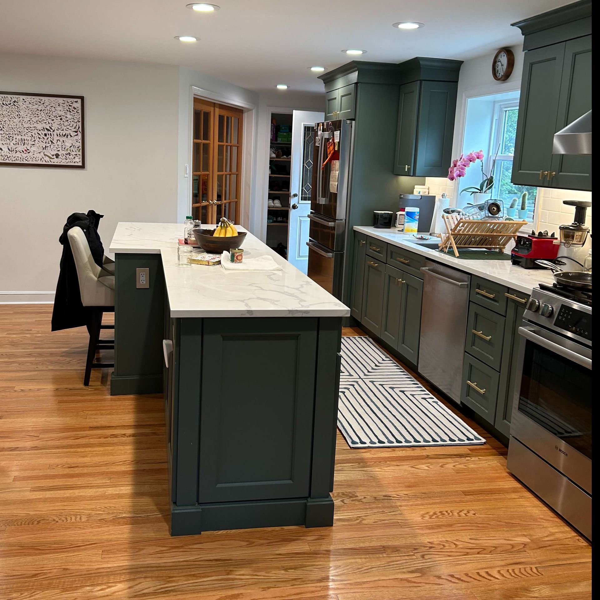 A kitchen with green cabinets and stainless steel appliances