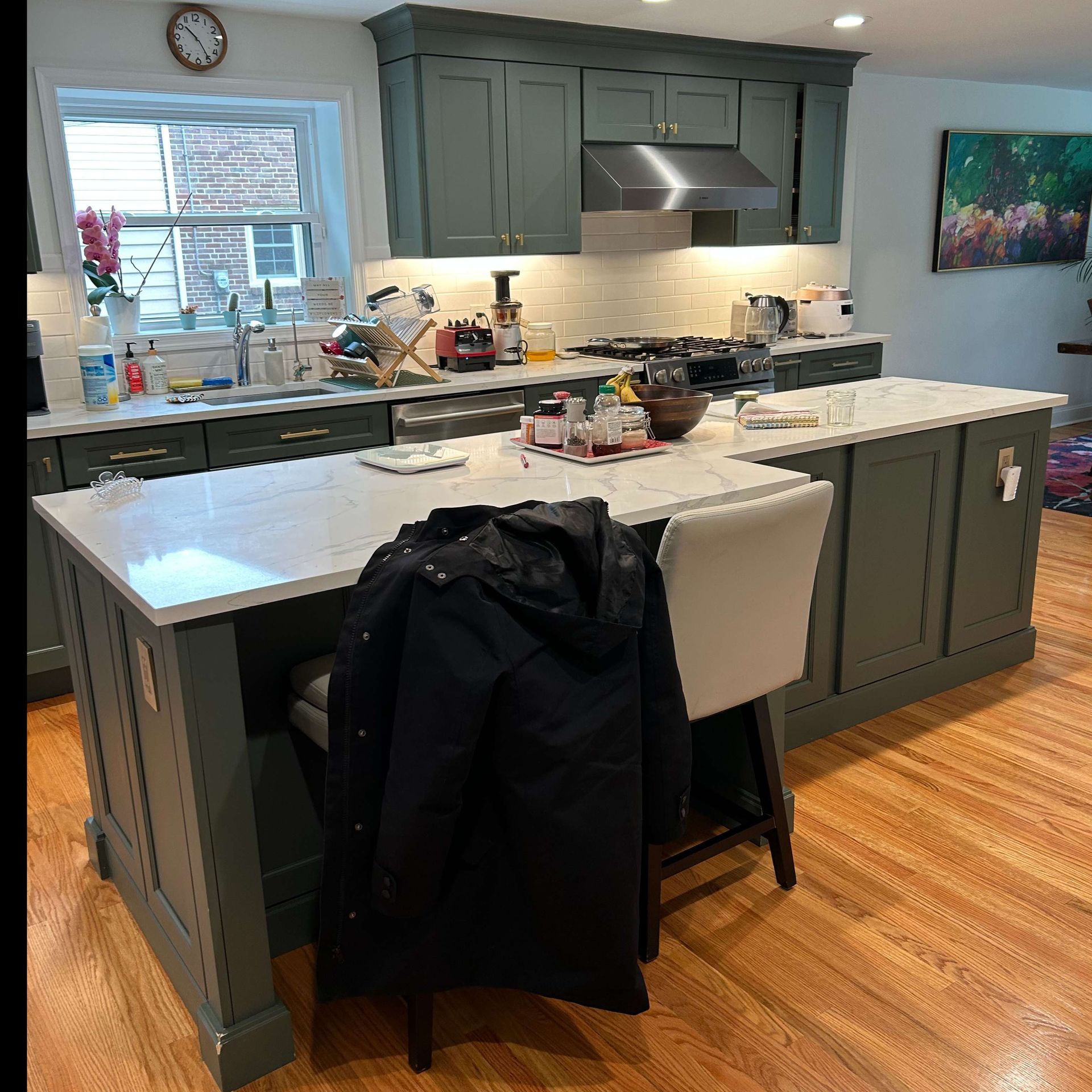 A kitchen with a large island and a clock on the wall.