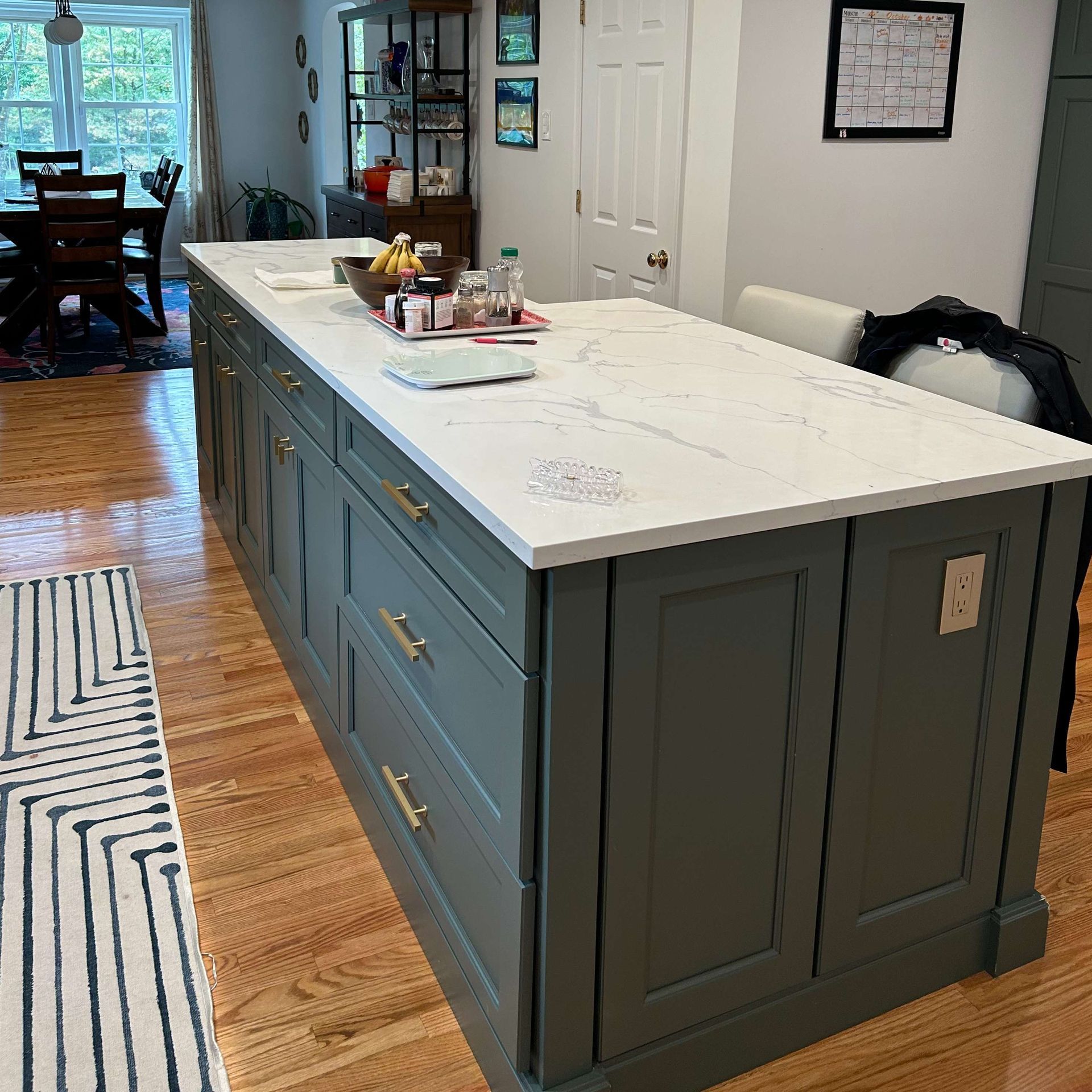 A kitchen with a large island and a marble counter top