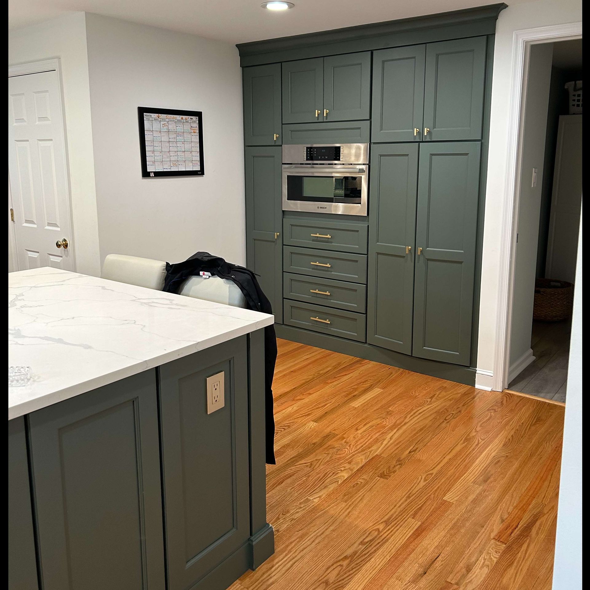 A kitchen with a large island and a stainless steel oven.