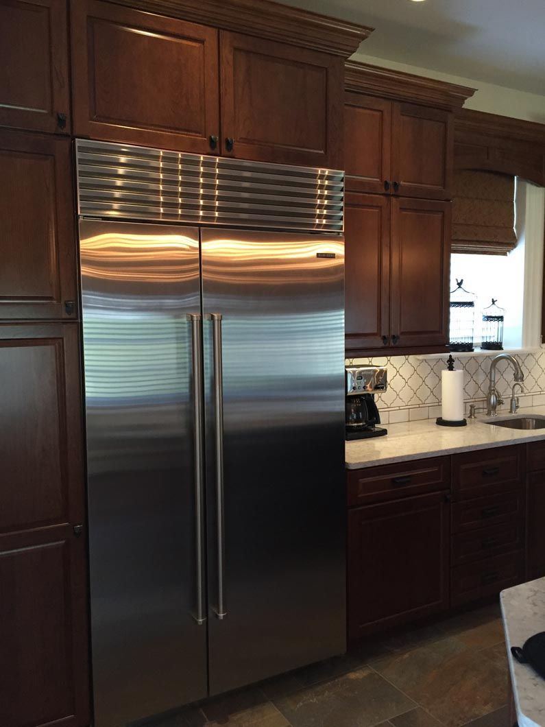 A kitchen with stainless steel appliances and wooden cabinets.