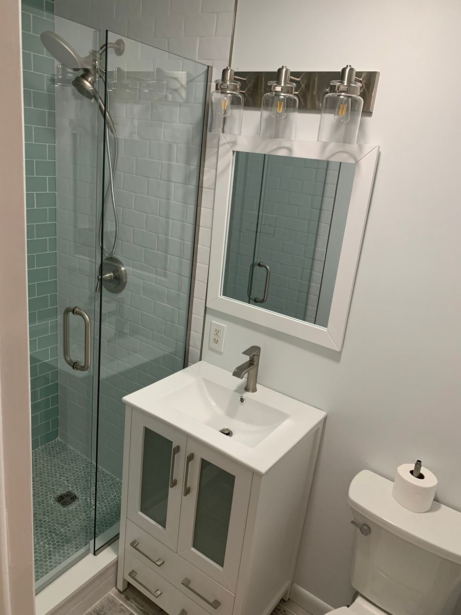 A bathroom with a sink , toilet and shower.