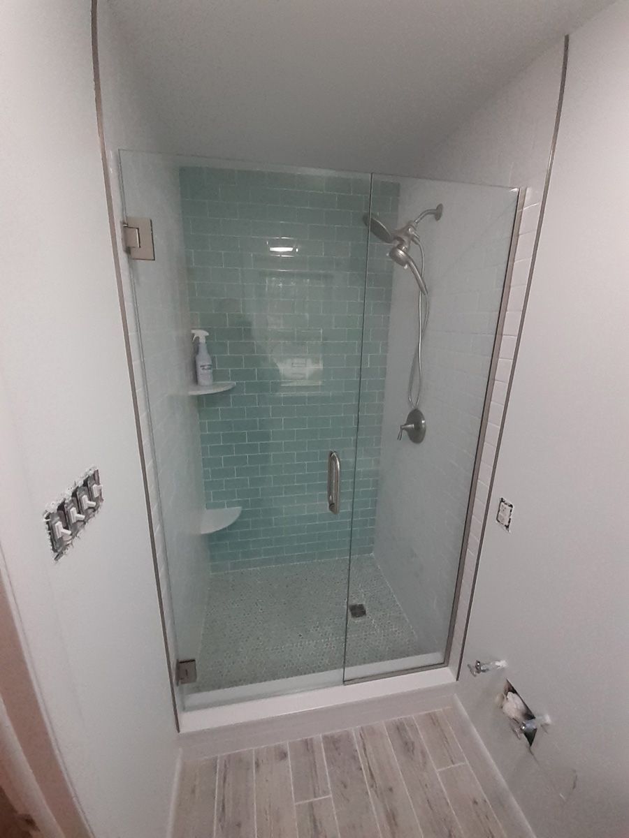 A bathroom with a glass shower door and a shower head.
