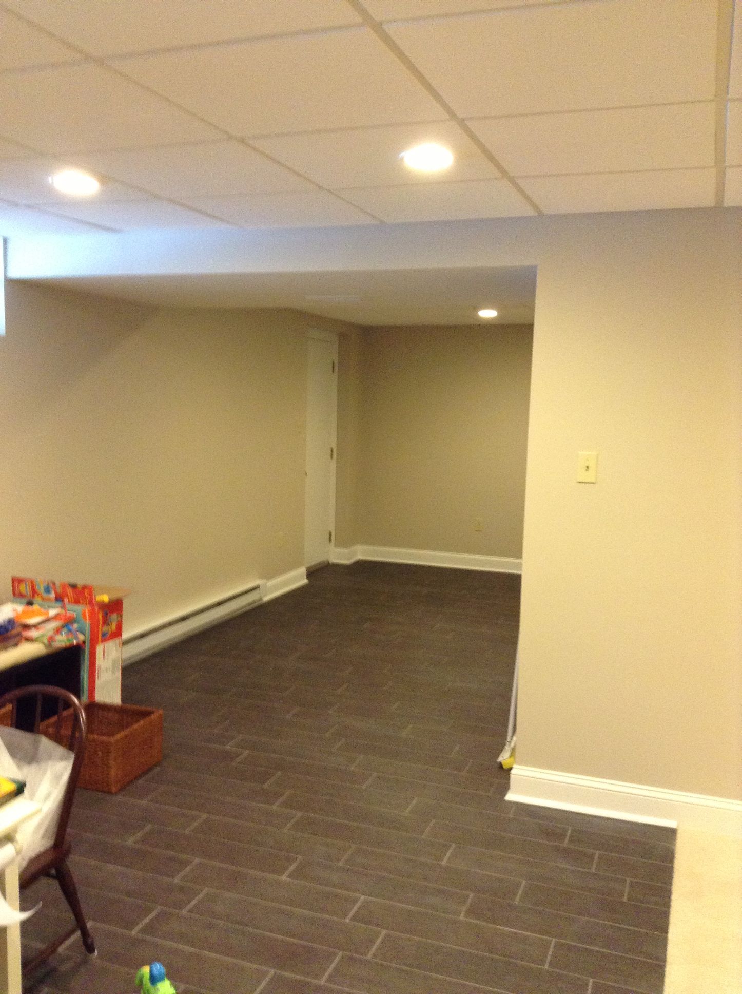 A basement with a carpeted floor and a desk
